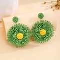 Detail of handmade woven raffia flower earrings in green and yellow for summer - Green