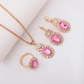 Elegant gold jewelry set featuring pink rhinestones on a necklace, earrings, and ring - Three-Piece Set / Oval-Pink