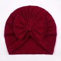 Macro detail of dark burgundy knitted baby turban hat with a large bow and herringbone texture - One Size / Red
