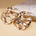 Macro detail of golden irregular crumpled metal earrings with hammered mirror texture - Gold