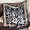 Retro thistle print silk scarf in black and beige with geometric borders draped on leather - Thistle Floral Print Black (XW-195)