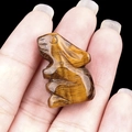 Miniature tiger eye stone rabbit figurine with golden luster held in hand - Tiger's Eye