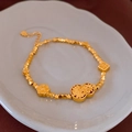 Vista detallada de una pulsera dorada con dijes de calabaza y flores en un plato - Dorado (Chapado en Oro Real)