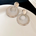 Detailed view of silver hollow circular hoop earrings with unique textured metal finish - Silver