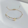 Details des verstellbaren böhmischen Miyuki-Perlenarmbands mit goldenem Anhänger und Kordel - Buchstabe O