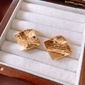 Close-up of 18k gold plated square stud earrings with hammered texture in a wooden box - Gold