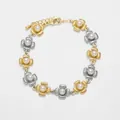 Detailed macro view of 18k gold plated flower chain bracelet with white pearls - Gold and Silver Two-Tone Pearl Flower Style