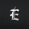 Macro shot of silver gothic letter E pendant with polished stainless steel texture - Letter E