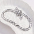 Macro dettaglio di un bracciale a croce in zirconi argentati su un piatto di ceramica decorato - Stile Croce / Platino Zircone Bianco