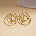 Detail showing three interlocking golden metal geometric rings with a polished finish - Ear Buckle / Gold