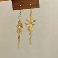 Détail de boucles d'oreilles papillons dorées avec de longues chaînes à pompons - Papillon Filigrane Doré à Franges