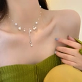 Baroque pearl necklace with silver heart pendant on a model wearing a green blouse - Pearl Tassel Necklace