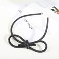 Close-up of sparkling black rhinestone bow headband with elegant gold metal end caps - Figure 8 Knot Full Rhinestone Headband / Black Zirconia