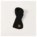 Detail of black chunky knit kids scarf featuring a vintage brown leather logo patch - Kids / Black