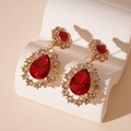 Dettaglio di orecchini vintage dorati con cristalli rossi a goccia e piccoli strass - Orecchini a pendente a goccia rossi