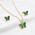 Detailed macro of gold butterfly necklace and earrings set with green stone on silk - Green