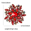 Spilla vintage a fiore con cristalli rossi, strass e misure su sfondo bianco neutro - Rosso
