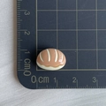 Vista macro detallada de un mini croissant de resina de 1,5 cm sobre escala de cm - 02*Pan de Concha Marrón