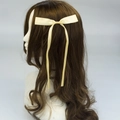 Elegante pinza para el pelo con lazo de satén beige en cabello castaño - Blanco Roto