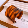 Macro detail of wide open cuff bracelet featuring amber tortoiseshell texture on velvet - Dark Amber Tortoiseshell Resin Bangle (47#)