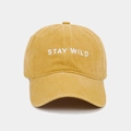 Gros plan sur la broderie STAY WILD d'une casquette de baseball vintage en coton jaune délavé - Réglable / Jaune Gingembre