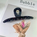 Large black acetate hair claw clip with colorful rhinestones on a magazine background - Cross Style - Black