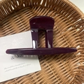 Glossy burgundy large claw clip with hollow square design on a woven background - Dark Red