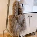 Detailed view of brown plush tote bag with soft faux fur texture hanging on a metal stand - Brown