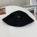 Detailed macro view of dark denim bucket hat fabric with a sleek gold metal accent - M / Black