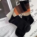 Retro black crew socks with colorful striped ribbed cuffs on minimalist magazine backdrop - One Size / Black Poly-Cotton