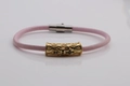 Detail of pink leather bracelet featuring gold hollow pattern tube and black crystal inlay - Gold G