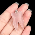 Pendentif en cristal rose en forme de dent avec bélière en métal sur fond noir profond - Quartz rose