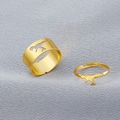 Detailansicht von zwei goldfarbenen Dinosaurier-Ringen auf grauem Stoffhintergrund - Partnerring / Gold Dinosaurier Stil (WR491)