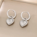 Dettaglio di orecchini a cuore argento con smalto bianco e finitura in metallo martellato - Acciaio (KE116099-Z)