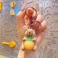 Capybara keychain with orange charm and brown metal ring for bags and keys decoration - Glowing Capybara - Brown