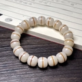 Zen style white bodhi root bracelet with medicine bead pattern on wooden table - One Line Sky Single Loop Style