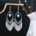 Close-up of Bohemian feather drop earrings with turquoise heart and vintage silver finish - E1316-3 Blue Feather Dangle