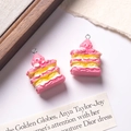 Macro detail of two pink layered Napoleon cake charms for DIY jewelry making and crafts - Pink + Yellow Filling