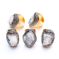 Macro detail of five gold druzy rings with white crystals and double rhinestone borders - Iridescent