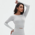 Detailopname van de lichtgrijze sportieve crop top met lange mouwen en gebreide textuur - S / Maanlichtwit