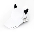 Close-up of white baseball cap with plush devil horns and metallic gothic charms - Safety Pin Tools White