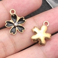 Schwarze Emaille-Kirschblüten-Anhänger mit Goldrand und Perle auf dem Finger - 1 Stück Schwarze Strass Kirschblüte 14x16mm