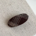 Detail of oval hair clip with brown and beige checkered wool fabric on linen background - Plaid Oval Duckbill Clip / Brown