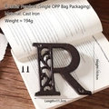 Vintage industrial cast iron letter R wall decor with screws on rustic wooden background - Letter R