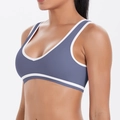 Side view detail of a grey-blue athletic sports bra with white trim on a female model - S / Top (7120) / Blue Gray