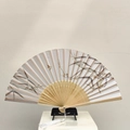 Vintage Chinese folding fan with ink bamboo pattern and white tassel on a stand - Clear Snow (Plum)