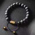 Close-up of snowflake obsidian and matte black stone beads with golden sliding clasp - Snowflake Woven Style