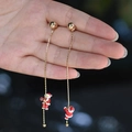 Detailaufnahme der asymmetrischen Weihnachts-Ohrringe mit kletterndem Weihnachtsmann - Kletternder Weihnachtsmann Goldkette Stil