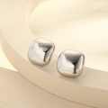Macro detail of geometric silver earrings with wavy texture on minimalist pedestal - Silver Rounded Square