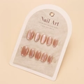 Detail of pink cat-eye press-on nails with sparkling rhinestones on a paper card - By1729 / Glue Type